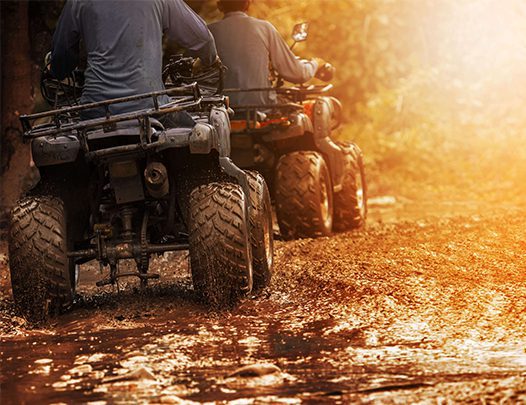 A group riding ATVs on a trail