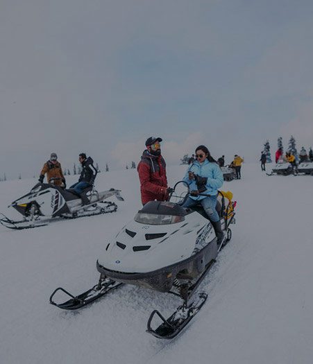 Groups of people riding snowmobiles