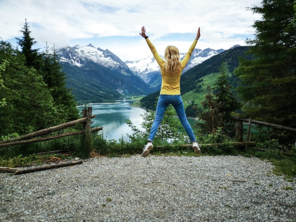 A young woman stretching on top of a mountain