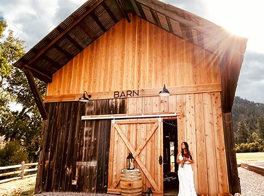 A happy bride standing in front of a barn