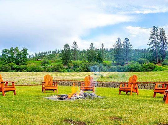 Wooden chairs around a fireplace on a ranch