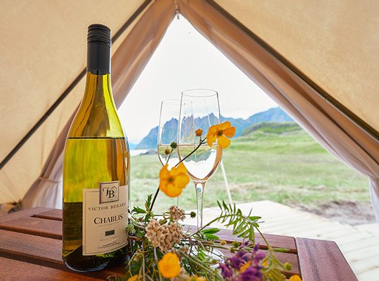 A wine bottle on a table in a luxury tent