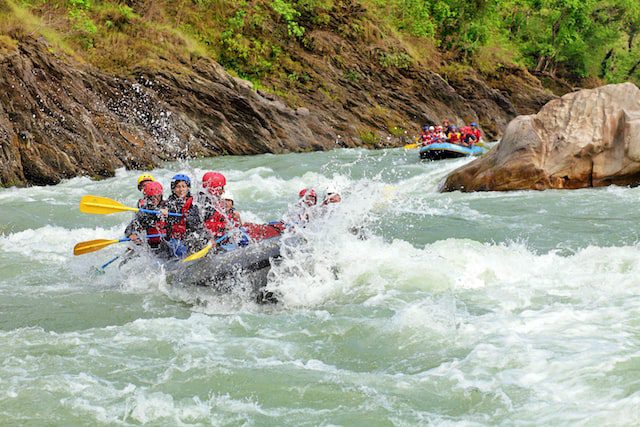 A group of people white water rafting