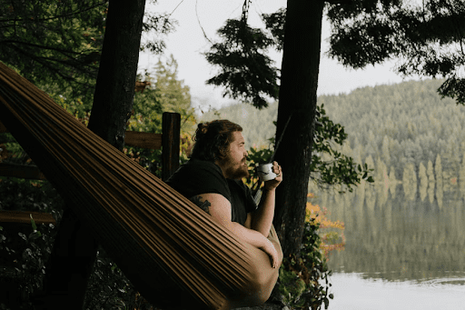 A man sitting in a hammock surrounded by nature