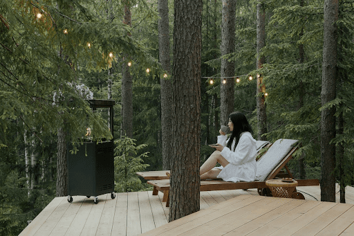 A woman sitting on a lounge chair and drinking a beverage