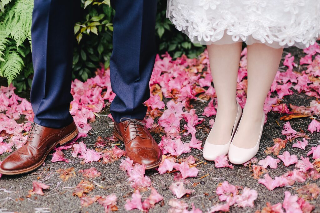 A bride and groom standing on a bed of pink flowers