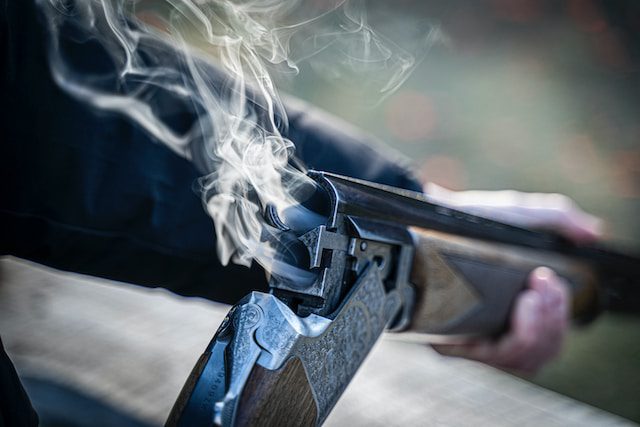 A person holding a smoking rifle